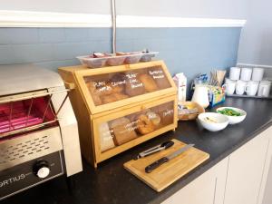 a kitchen counter with a box of bread and a knife at Park Hotel & Apartments in Hull