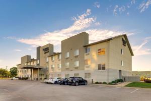 a hotel with two cars parked in a parking lot at Fairfield Inn & Suites by Marriott Fort Worth I-30 West Near NAS JRB in Fort Worth