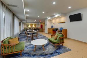 a waiting room with chairs and a table and a tv at Fairfield Inn & Suites by Marriott Fort Worth I-30 West Near NAS JRB in Fort Worth