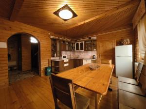 a wooden kitchen with a wooden table and a refrigerator at Darynka in Yaremche