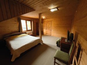 a bedroom in a log cabin with a bed and a tv at Darynka in Yaremche