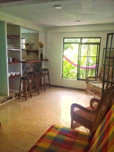 ein Wohnzimmer mit einem Tisch, Stühlen und einem Fenster in der Unterkunft Windy View Guest House in Providencia