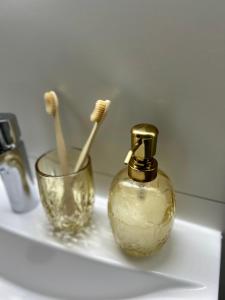 a bathroom sink with a bottle of soap and tooth brushes at Room21 FREE GARAGE in Novi Sad