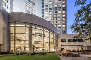 un gran edificio de cristal con césped delante en The Westin Beijing Financial Street, en Beijing