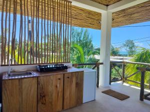 a kitchen with wooden cabinets and a view of the ocean at Sand Beach Boutique Villas in Bwejuu