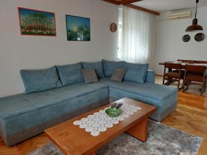 a living room with a blue couch and a coffee table at Apartment Central in Knin