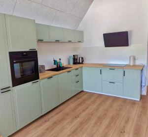 a kitchen with white cabinets and a black appliance at Norderbarg in Bredstedt