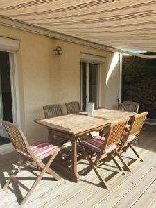 una mesa de madera y 4 sillas en una terraza en LA ROCHELLE classé 3 étoiles, en Nieul-sur-Mer