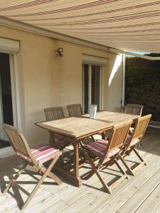 a wooden table and four chairs on a deck at LA ROCHELLE classé 3 étoiles in Nieul-sur-Mer