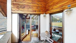 a house with wooden ceilings and a table in a room at Abitaziun Furtschellas 8 - Sils Maria in Sils Maria