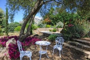 サルテーヌにあるChambre d'Hôtes Domaine Pero Longoの花の咲く庭園に椅子2脚とテーブル1台