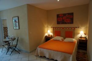 a bedroom with a bed with an orange bedspread at Chambre d'Hôtes Domaine Pero Longo in Sartène