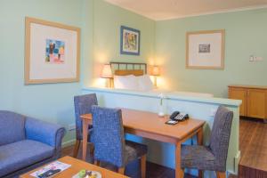 um quarto de hotel com uma mesa e uma cama em Protea Hotel by Marriott Dar es Salaam Oyster Bay em Dar es Salaam