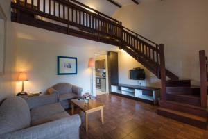 a living room with a couch and a staircase at Protea Hotel by Marriott Dar es Salaam Oyster Bay in Dar es Salaam