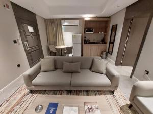 a living room with a couch and a kitchen at شقق هلا التميز للشقق المخدومة in Jeddah