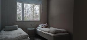 a room with two beds and a window at New Villa w/sauna, jacuzzi &wifi in Hämeenlinna