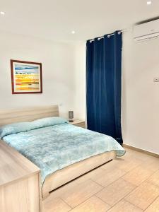 1 dormitorio con cama y cortina azul en PALAZZO PROIETTI BILOCALE 3, en Biella