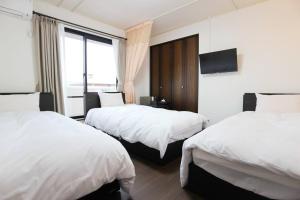 um quarto de hotel com duas camas e uma televisão em 志摩の別荘 em Shima