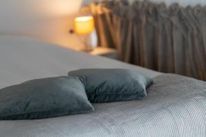 a bed with two pillows on top of it at Loft van 90 m² met grote binnentuin. in Antwerp