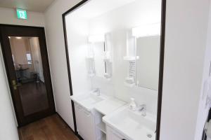 a white bathroom with two sinks and a mirror at 志摩の別荘 in Shima
