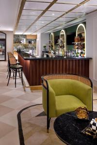 - un hall avec un canapé vert et un bar dans l'établissement 1 Bedroom Suite @ The address Golf Marassi Resort, à El Alamein