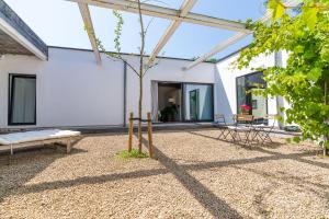 uma casa branca com um banco e uma mesa em Loft van 90 m² met grote binnentuin. em Antuérpia