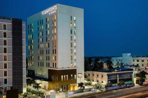 un grand bâtiment avec un panneau sur son côté dans l'établissement Four Points by Sheraton Chennai OMR, à Chennai