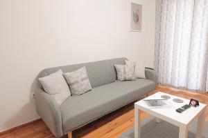 Sala de estar con sofá gris y mesa en Uranus Apartment, en Tesalónica