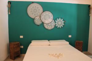 a bedroom with a bed with a green wall at DOMUS MARIS in Monopoli