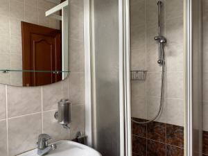 a bathroom with a sink and a shower with a mirror at Youth Hostel & Penzion Bledec in Bled