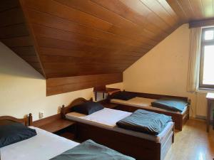 3 camas en una habitación con techo de madera en Youth Hostel Bledec, en Bled