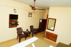 a living room with a table and chairs and a mirror at Holidayincoorg Brick lane in Madikeri