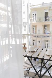 una mesa de picnic en un balcón con un edificio en Uranus Apartment, en Tesalónica