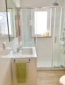 a white bathroom with a sink and a shower at Bedrooms AP Garden in Lagos