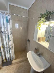 a bathroom with a sink and a shower curtain at Vereniki 1 in Kriopigi +32 photos