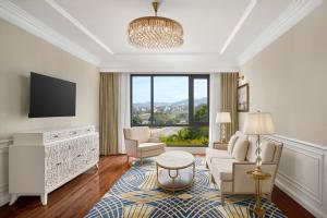 a living room with a couch and a tv at Four Points by Sheraton Lang Son in Lạng Sơn