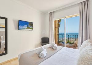 a bedroom with a bed and a view of the ocean at Marina XI Lovely apartment inside Wyndham Resort in Mijas Costa