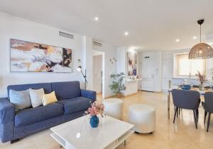 ein Wohnzimmer mit einem blauen Sofa und einem Tisch in der Unterkunft Marina XI Lovely apartment inside Wyndham Resort in Mijas Costa