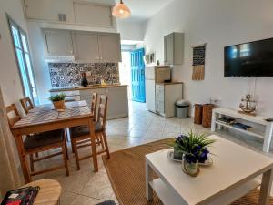 a kitchen and a living room with a table and chairs at Ritzi Apartment in Symi