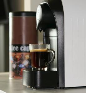 a coffee maker is making a cup of coffee at Falcon Apartment Center 2 Metro Złote Tarasy in Warsaw
