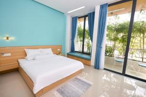 a bedroom with a bed and a large window at Truc Home in Danang