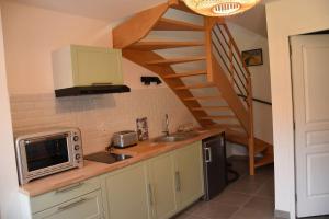 a kitchen with a sink and a spiral staircase at Gîte An Daou Tok in Mellionnec