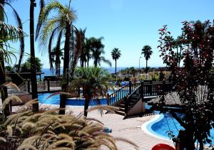 un complejo con piscina y palmeras en Marina XI Lovely apartment inside Wyndham Resort, en Mijas Costa