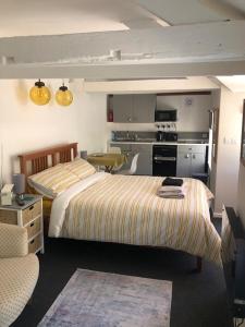 two beds in a room with a kitchen and a room at Bracken's Retreat in Lostwithiel