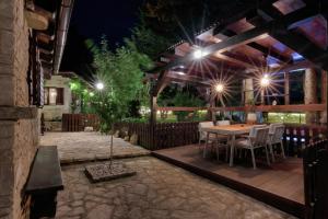 Holiday Home Giardino Marino في بومير: فناء خشبي مع طاولة وكراسي في الليل