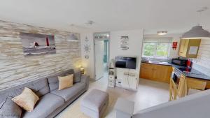 a living room with a couch and a kitchen at 36 Strawberry Hill, Tolroy Manor in Hayle