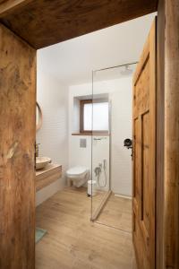 a bathroom with a glass shower and a toilet at Къща за гости Остриля in Cherni Vit