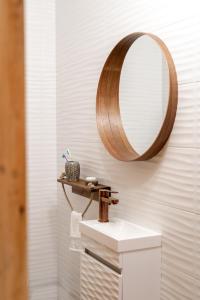 uma casa de banho com um lavatório e um espelho na parede em Къща за гости Остриля em Cherni Vit