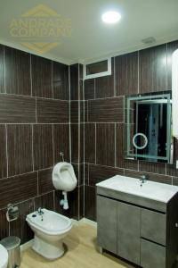 ein Badezimmer mit Waschbecken, Toilette und Spiegel in der Unterkunft Refúgio da Suite 6 in Pinhão