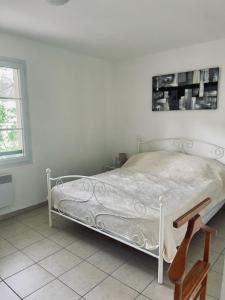 uma cama branca num quarto branco com uma janela em Villas A Torra em Patrimonio